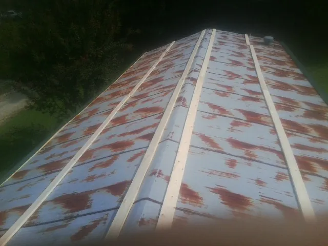 Rusted metal roof panels with new wood purlins before replacement — Storm Damage Roof Repair in Alapaha by Roofing Brothers